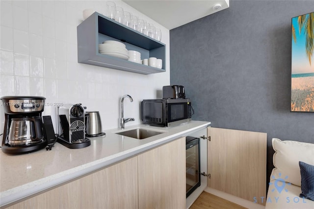 601 NE 1st Ave Unit 1602, Miami, FL 33132 - kitchen with open shelves, light stone counters, a sink, beverage cooler, and decorative backsplash
