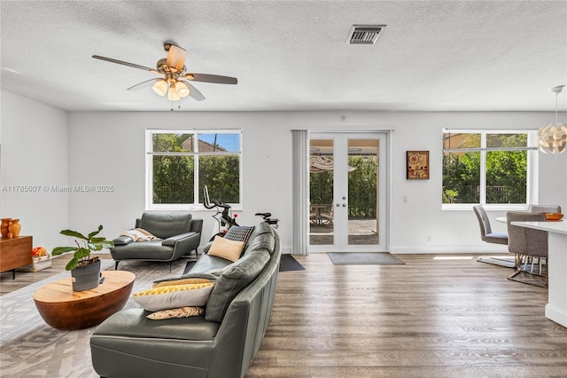 living room with visible vents, a wealth of natural light, hardwood / wood-style flooring, and a textured ceiling