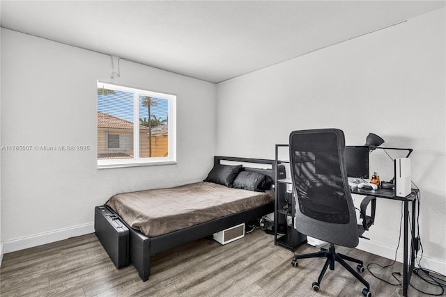 bedroom featuring wood finished floors and baseboards