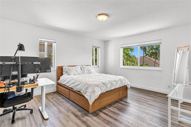 bedroom with baseboards and wood finished floors