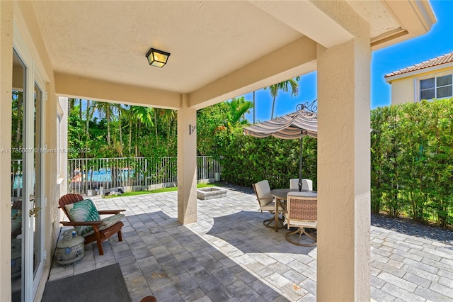 view of patio / terrace with outdoor dining space, fence, and a fire pit