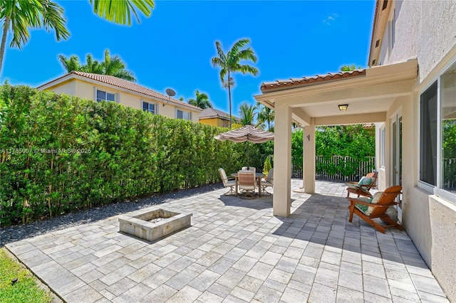 view of patio / terrace featuring outdoor dining space, fence, and a fire pit