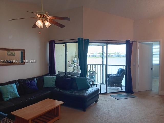 living room with a ceiling fan, carpet, and high vaulted ceiling