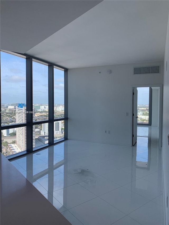 851 NE 1st Ave Unit 3002, Miami, FL 33132 - empty room with expansive windows, light tile patterned floors, visible vents, and a view of city