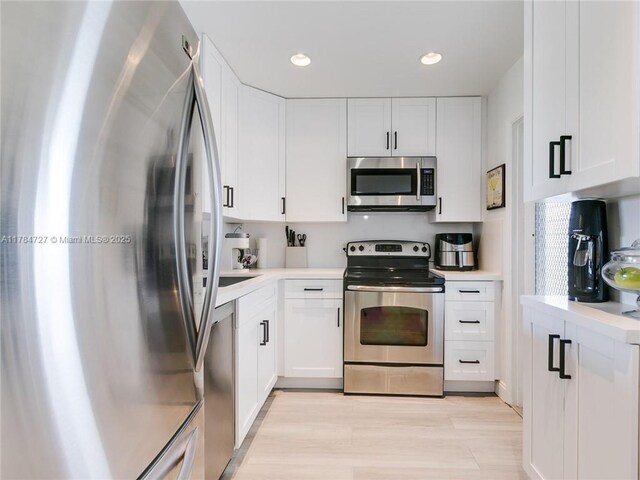 1425 Atlantic Shores Blvd Unit 605, Hallandale Beach, FL 33009 - kitchen with light countertops, white cabinets, recessed lighting, and stainless steel appliances