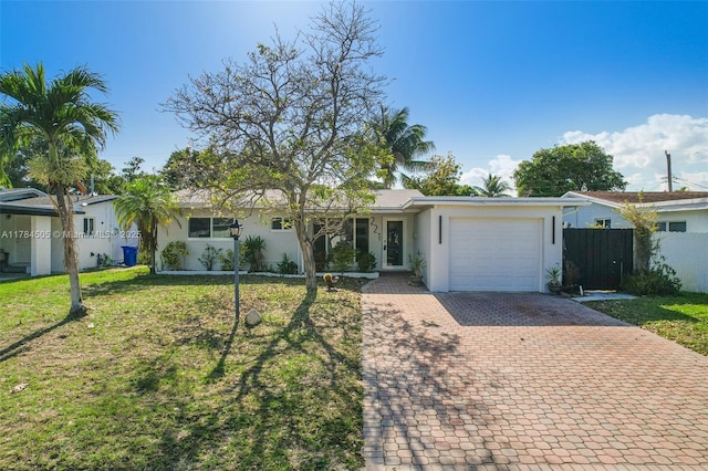 221 SW 28th Ter, Fort Lauderdale, FL 33312 - single story home with stucco siding, decorative driveway, a front yard, a garage, and fence