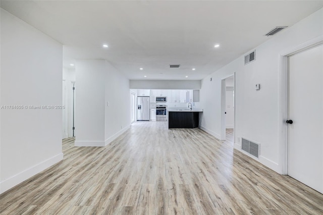 221 SW 28th Ter, Fort Lauderdale, FL 33312 - unfurnished living room with visible vents, light wood-style flooring, and baseboards