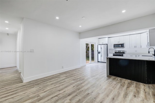 221 SW 28th Ter, Fort Lauderdale, FL 33312 - kitchen featuring white cabinets, a sink, appliances with stainless steel finishes, recessed lighting, and light wood finished floors