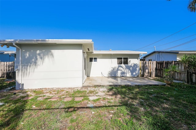 221 SW 28th Ter, Fort Lauderdale, FL 33312 - back of property featuring fence, a patio, a lawn, and stucco siding