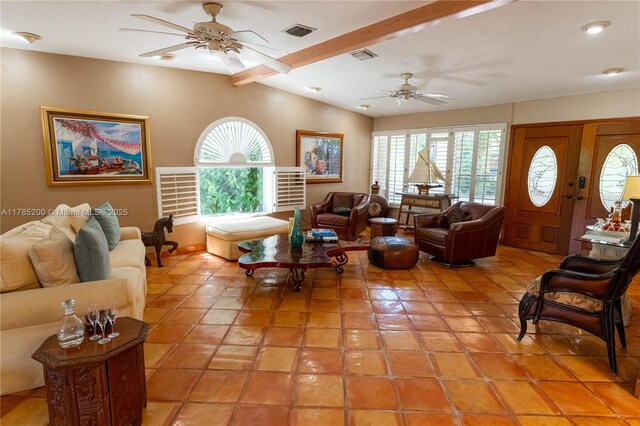 living room featuring ceiling fan, vaulted ceiling, and light tile patterned floors