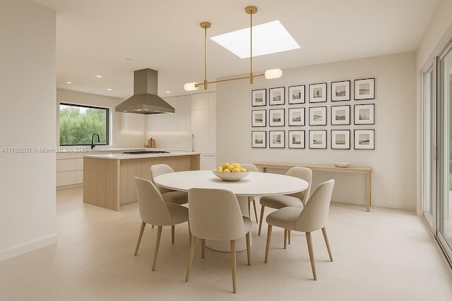 dining room featuring a skylight, recessed lighting, and baseboards