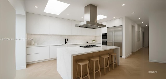 kitchen featuring modern cabinets, island range hood, appliances with stainless steel finishes, a skylight, and a sink