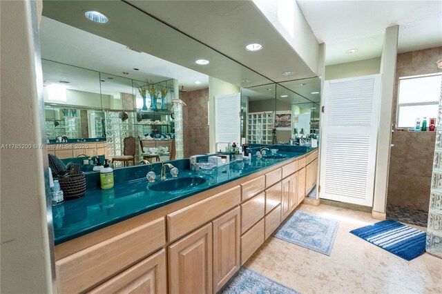 full bath featuring a tile shower, double vanity, and recessed lighting