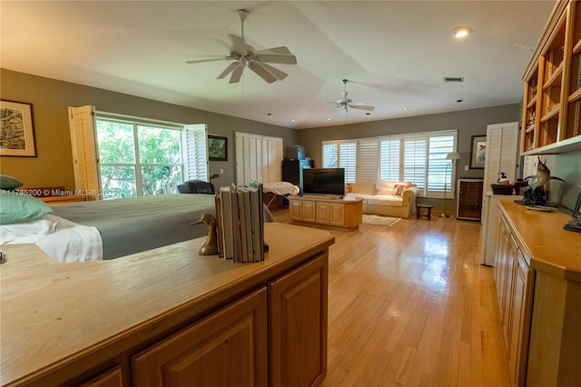 kitchen with open floor plan, ceiling fan, light wood-style floors, open shelves, and vaulted ceiling