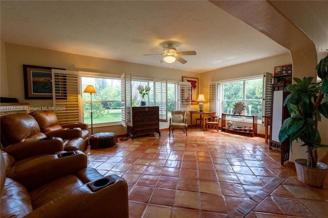 living area featuring a ceiling fan and baseboards