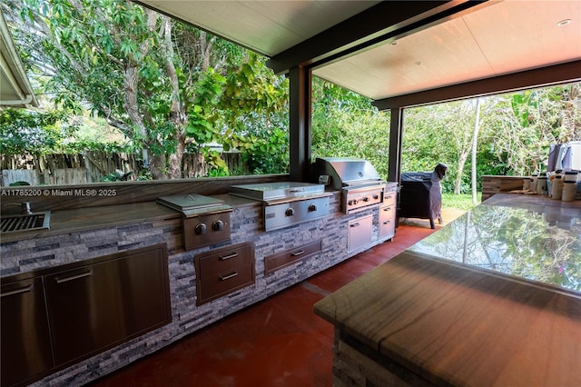 view of patio / terrace featuring grilling area, fence, and an outdoor kitchen