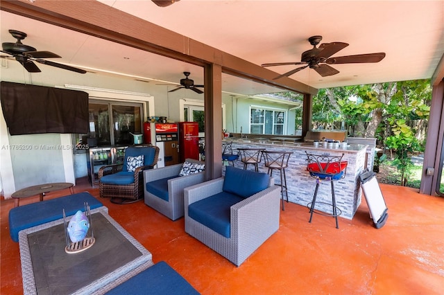 view of patio with a ceiling fan, an outdoor kitchen, and an outdoor living space