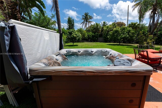 view of swimming pool with a hot tub and a lawn