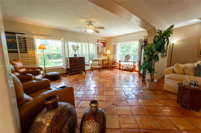 living room with ceiling fan, tile patterned flooring, and baseboards