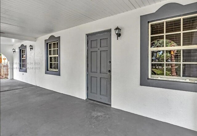 doorway to property featuring stucco siding