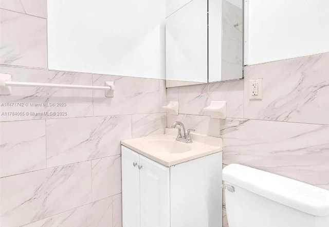 half bath featuring toilet, backsplash, tile walls, and vanity