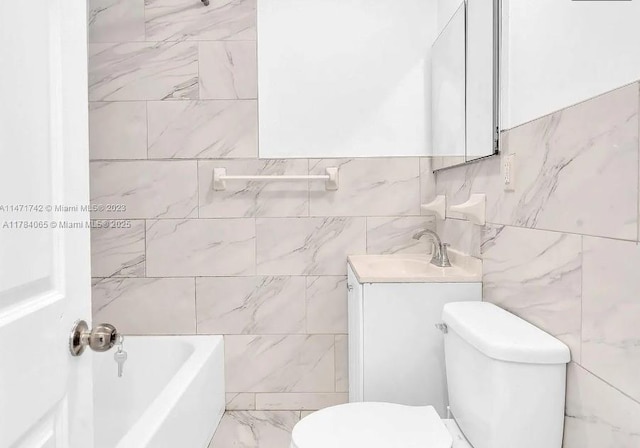 bathroom featuring toilet, a bathing tub, vanity, and tile walls