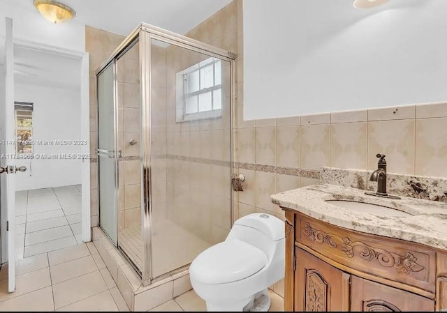full bathroom with vanity, tile patterned flooring, toilet, tile walls, and a stall shower
