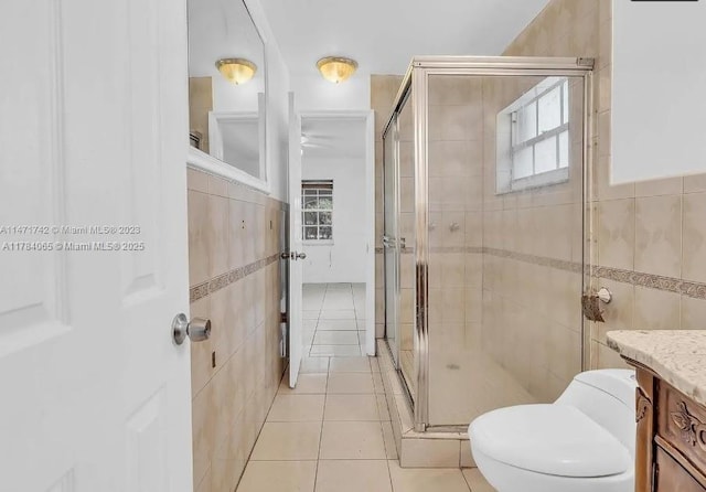 full bathroom with tile walls, a wealth of natural light, and a stall shower
