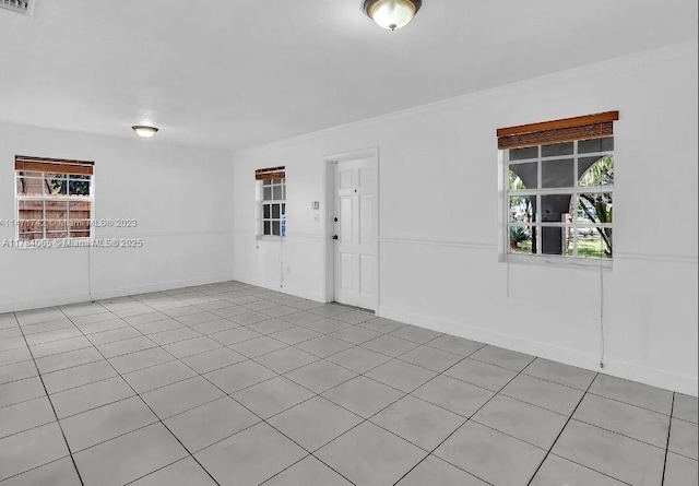 unfurnished room featuring crown molding and light tile patterned floors
