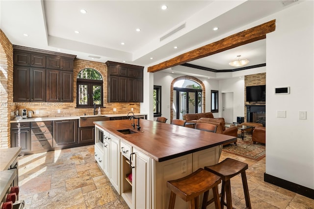 1511 Alegriano Ave, Coral Gables, FL 33146 - kitchen featuring a sink, stone tile flooring, a raised ceiling, and recessed lighting