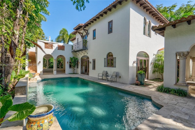1511 Alegriano Ave, Coral Gables, FL 33146 - back of property with stucco siding, a patio area, an outdoor pool, and a balcony