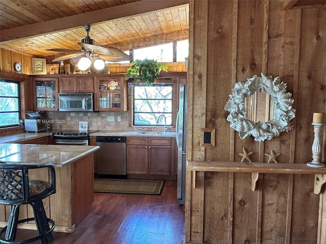 kitchen featuring wooden walls, a sink, stainless steel appliances, wooden ceiling, and dark wood-style floors