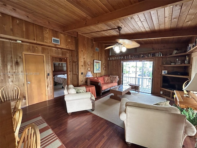 living room with wooden walls, ceiling fan, wood finished floors, beamed ceiling, and visible vents
