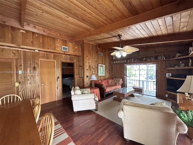 living area with visible vents, wood walls, wood finished floors, beamed ceiling, and wooden ceiling