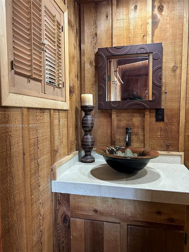 bathroom featuring vanity and wood walls