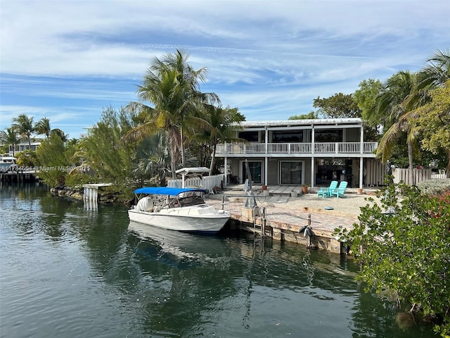 dock area with fence, a patio, and a water view
