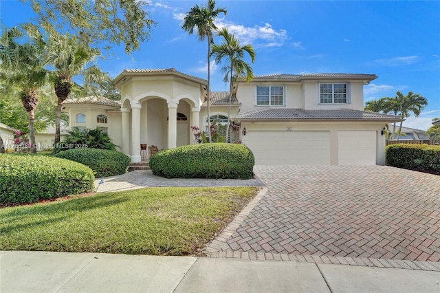1951 NW 167th Ter, Pembroke Pines, FL 33028 - mediterranean / spanish-style house with a tiled roof, a front lawn, a garage, stucco siding, and decorative driveway