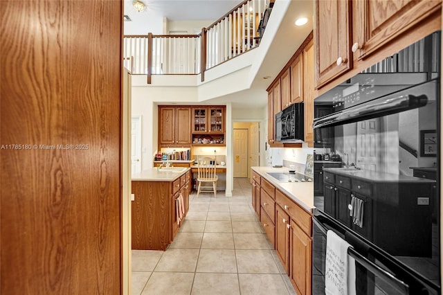1951 NW 167th Ter, Pembroke Pines, FL 33028 - kitchen featuring brown cabinets, a towering ceiling, light countertops, light tile patterned floors, and black appliances