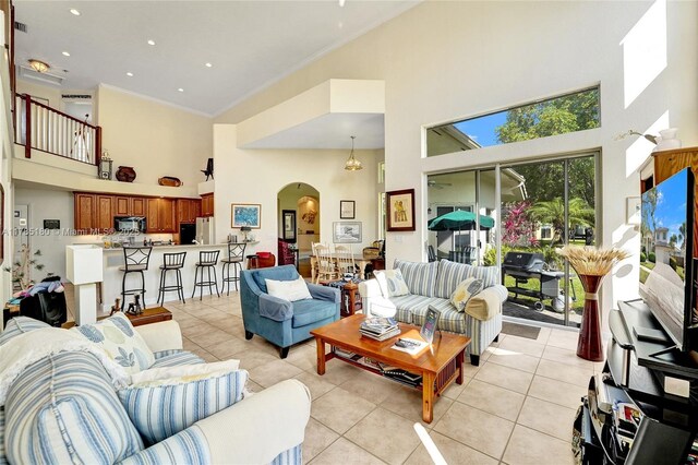 1951 NW 167th Ter, Pembroke Pines, FL 33028 - living area featuring crown molding, light tile patterned floors, arched walkways, a towering ceiling, and recessed lighting
