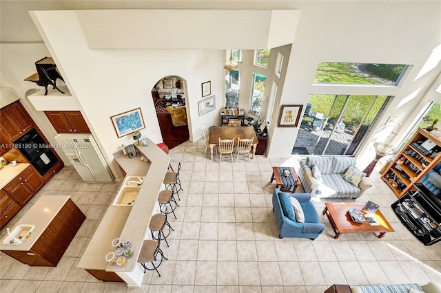 1951 NW 167th Ter, Pembroke Pines, FL 33028 - living area with light tile patterned floors, arched walkways, a towering ceiling, and plenty of natural light