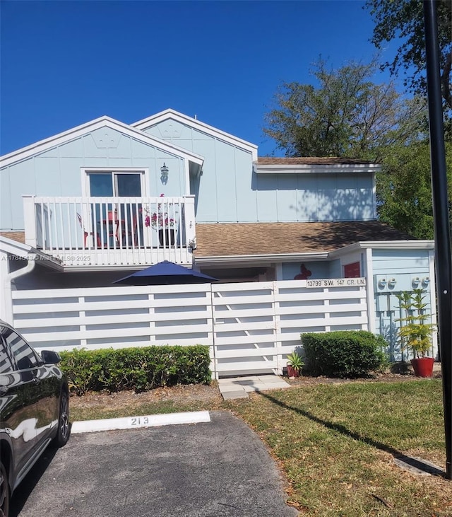 13799 SW 147th Cir Ln Unit 3, Miami, FL 33186 - view of front of house featuring a balcony, uncovered parking, a fenced front yard, and roof with shingles