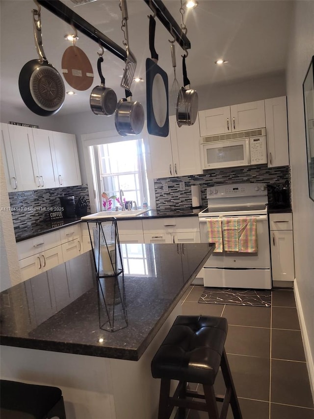 13799 SW 147th Cir Ln Unit 3, Miami, FL 33186 - kitchen with tasteful backsplash, white appliances, a kitchen bar, white cabinetry, and tile patterned flooring