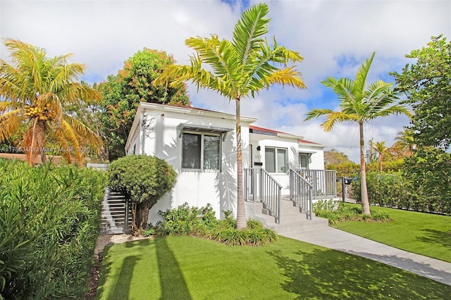 view of front facade with a front yard and stucco siding