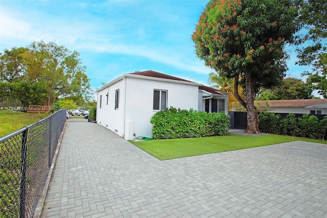 manufactured / mobile home with a front yard, fence, and stucco siding
