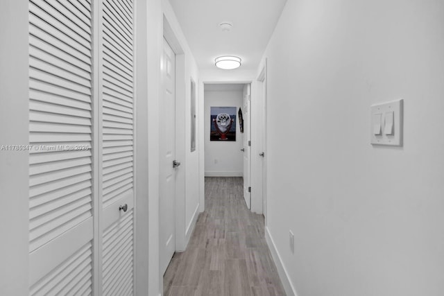 hallway with baseboards and light wood-type flooring