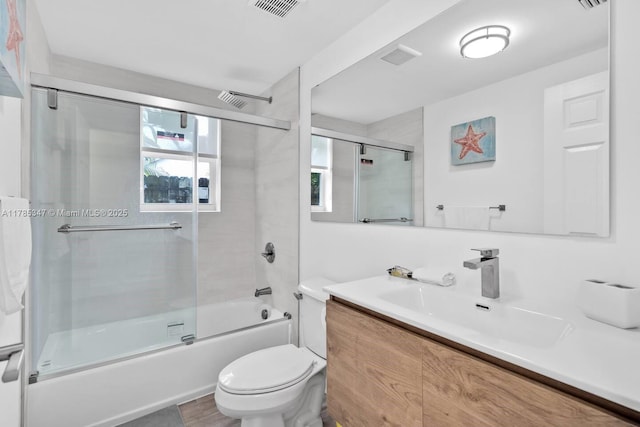full bathroom with vanity, enclosed tub / shower combo, visible vents, and toilet