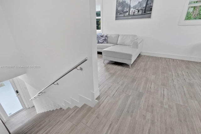 stairs featuring plenty of natural light, baseboards, and wood finished floors