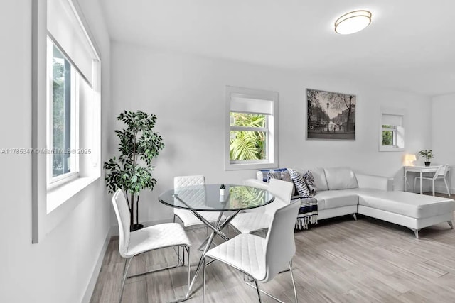 dining space with baseboards and wood finished floors