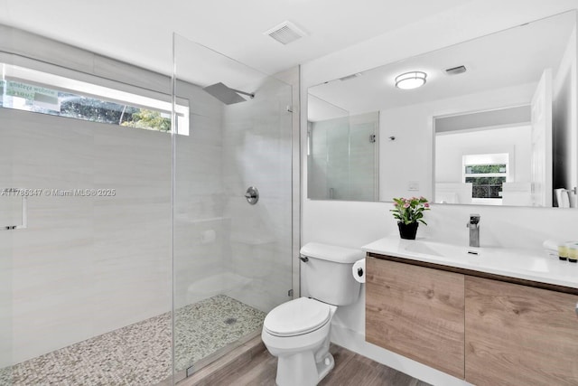 bathroom with visible vents, a shower stall, wood finished floors, and a healthy amount of sunlight