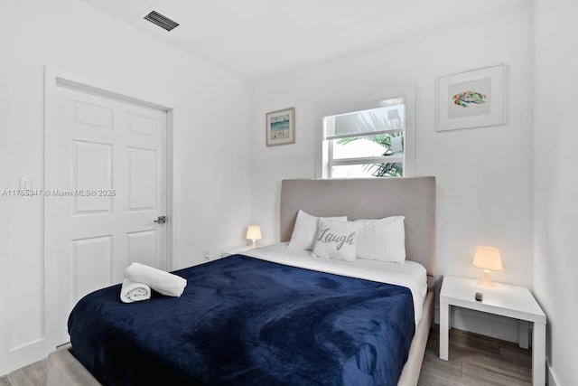 bedroom featuring visible vents and wood finished floors